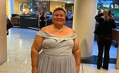 Kerry wearing a ball dress standing in a large hall